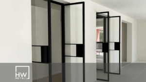 Zwei moderne Pivot-Türen, aus Metall und aus Glas, nebeneinander in einem stilvollen Innenraum.