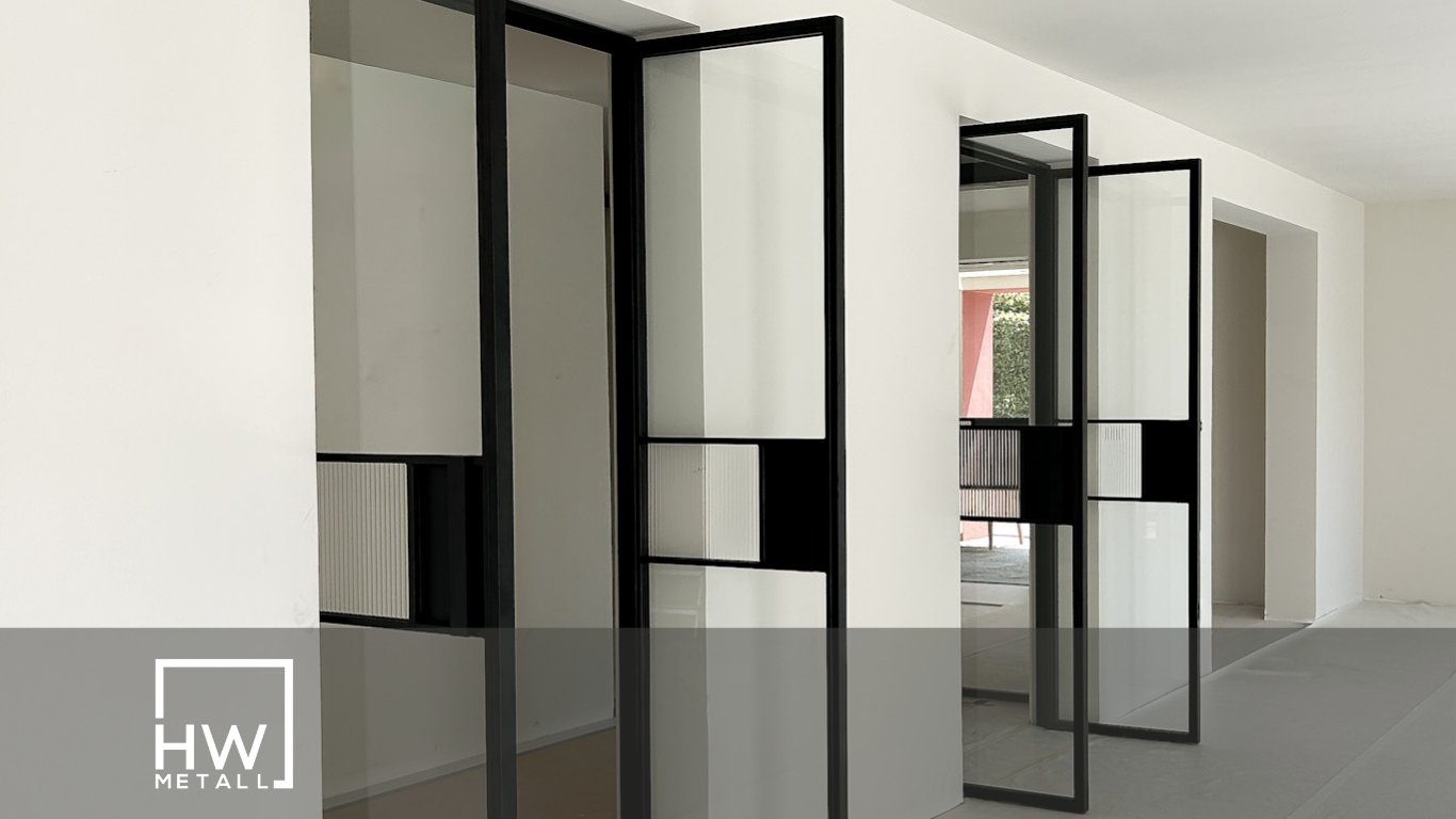 Zwei moderne Pivot-Türen, aus Metall und aus Glas, nebeneinander in einem stilvollen Innenraum.
