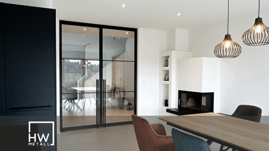 Moderne Lofttür mit Glas- und Stahlrahmen in einem kleinen, hellen Wohnzimmer – lässt Licht durch und verbindet zwei Räume offen miteinander.