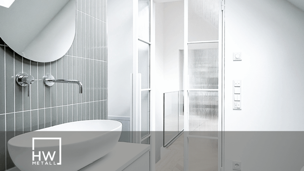 Eine Helle Lofttür im Bad neben Spiegel und Waschbecken