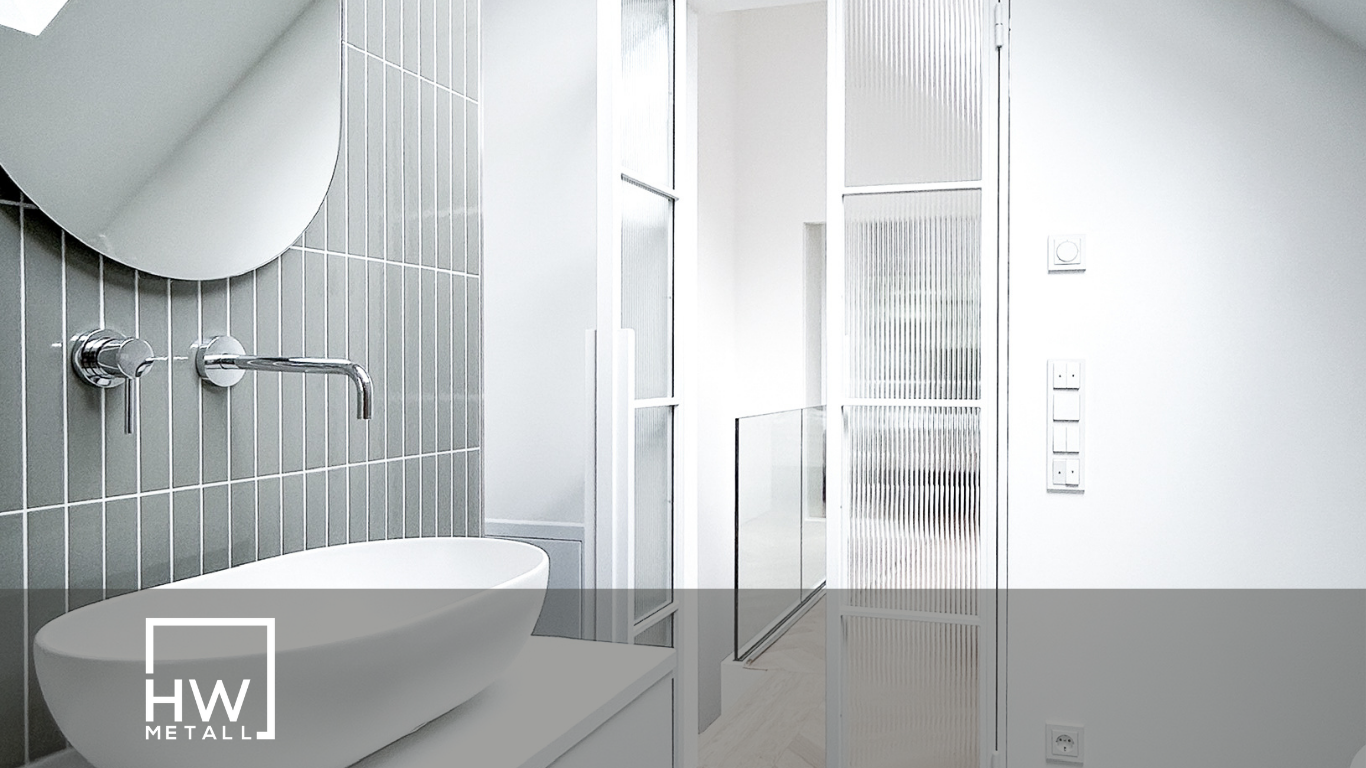 Eine Helle Lofttür im Bad neben Spiegel und Waschbecken